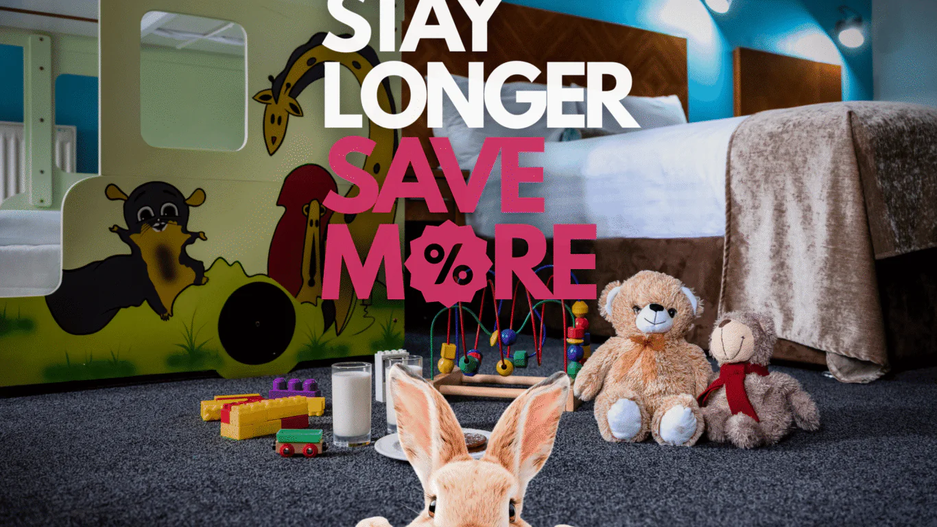 Family hotel room with cosy bed, colourful kids' play area, toys, and welcoming atmosphere for extended stays.