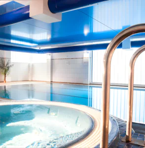 Spacious indoor pool with adjacent hot tub, modern design and relaxing atmosphere, perfect for unwinding at our luxury hotel.