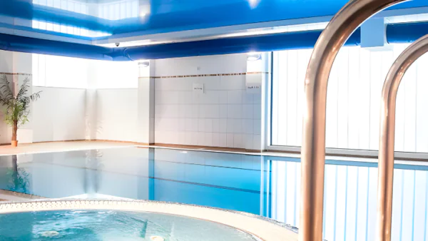 Spacious indoor pool with adjacent hot tub, modern design and relaxing atmosphere, perfect for unwinding at our luxury hotel.
