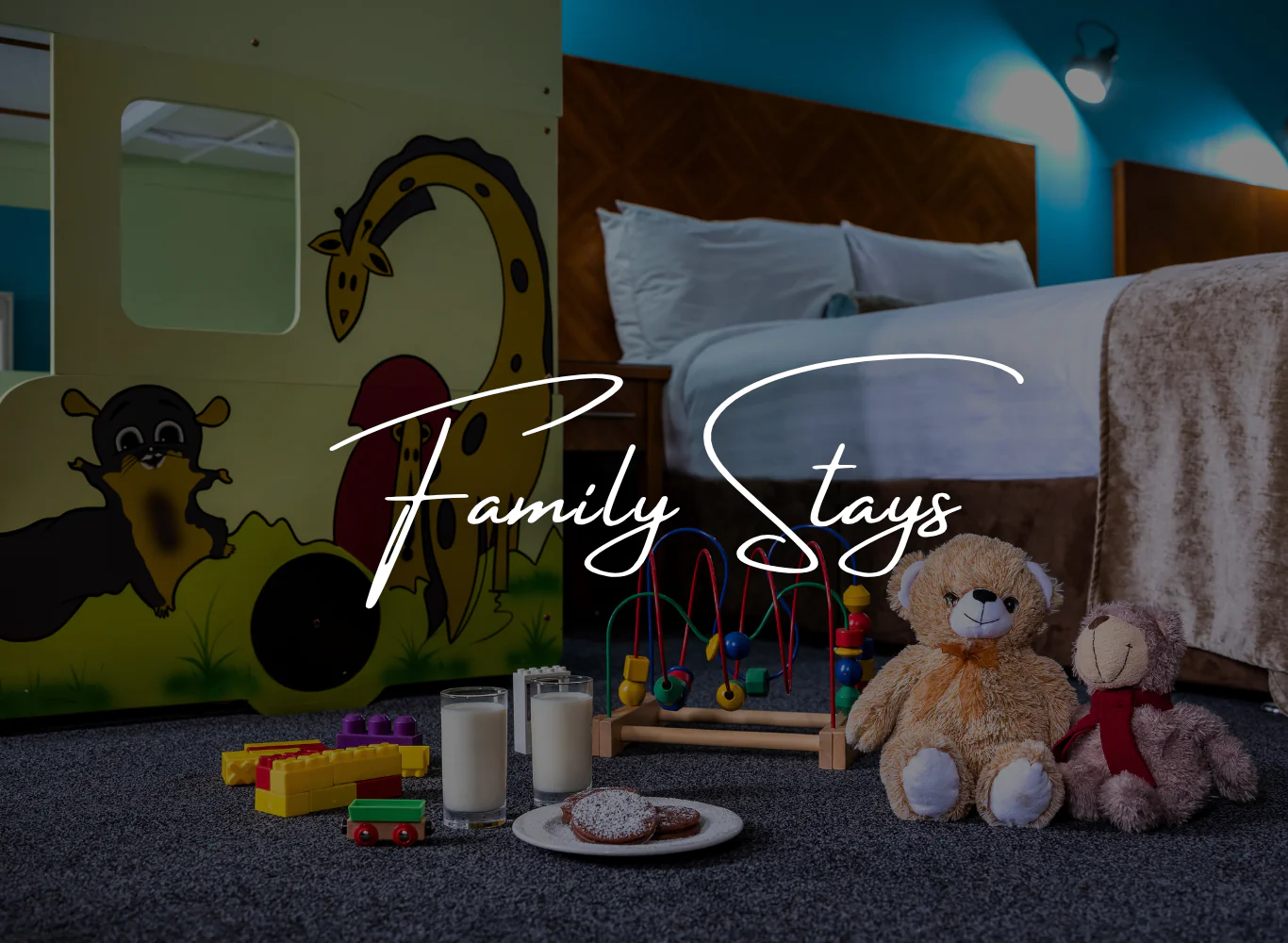 Family-friendly hotel room with bunk beds, toys, and cosy double bed; ideal for a comfortable family stay.