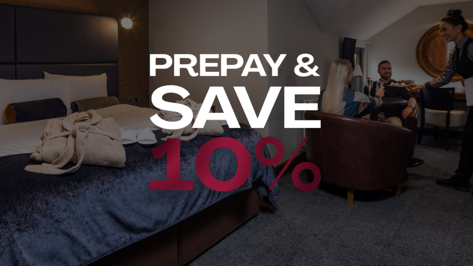 Elegant hotel room with cosy seating, plush bed, robes, and a welcoming atmosphere. Enjoy prepay savings of 10%.