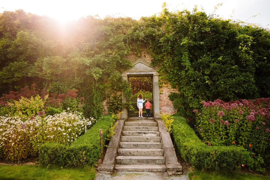 Mount Congreve Gardens Waterford Guests explore a walled garden with vibrant flowers, lush greenery, and scenic paths at our charming countryside hotel.