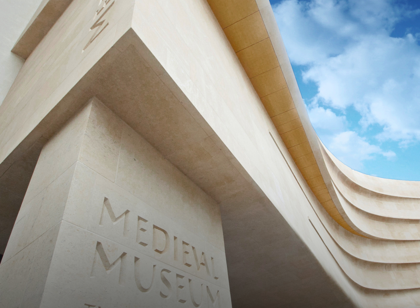 Stunning view of modern museum entrance with architectural curves and blue sky, inviting guests to explore cultural attractions.