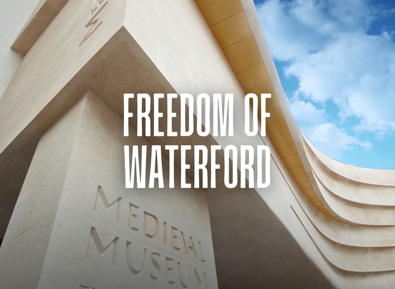 Elegant stone facade of Medieval Museum against blue sky, showcasing Waterford's rich history and cultural heritage.