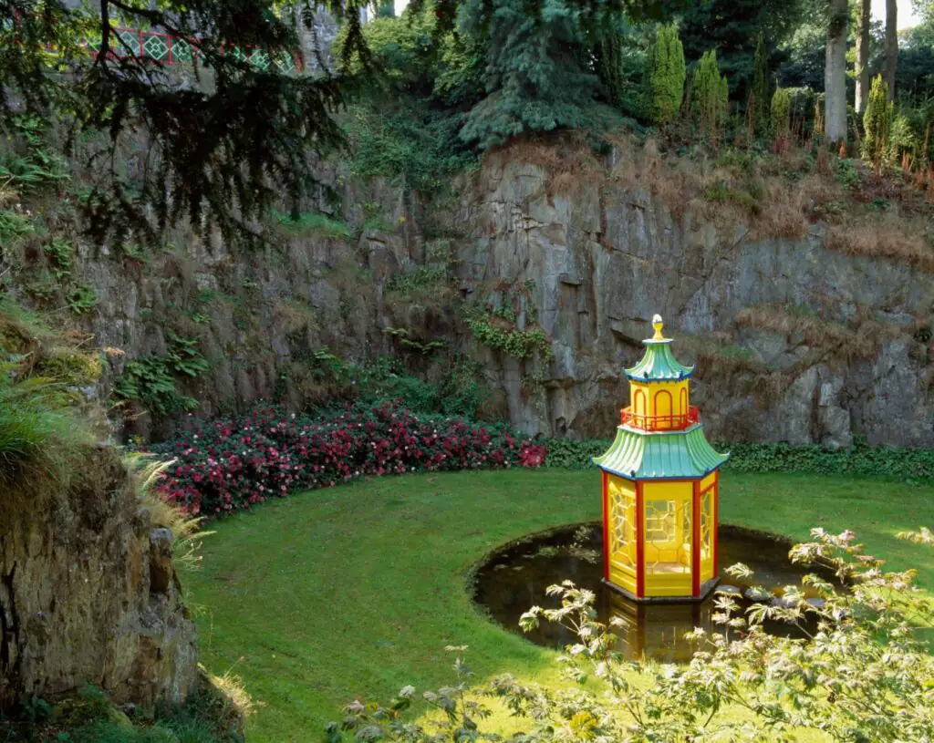 Mount Congreve Gardens Waterford Guests enjoy a vibrant Asian-style pagoda surrounded by lush gardens and rocky cliffs ideal for peaceful relaxation.