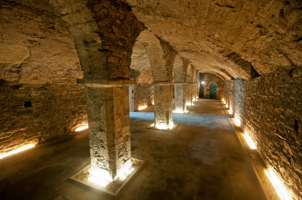 Medieval Museum Historic stone cellar with archways and warm lighting, perfect for unique hotel event experiences.