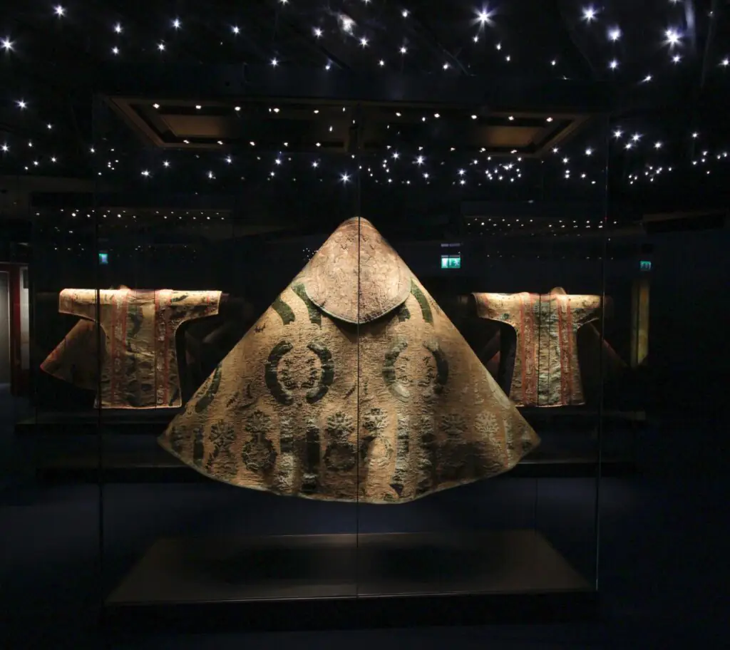 Medieval Museum Illuminated traditional robes in a glass display under a starry ceiling, showcasing cultural heritage at the hotel.