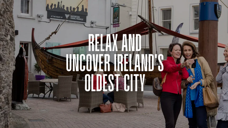 Guests explore a vibrant outdoor café with a Viking ship display in Waterford, enjoying local heritage and culture.