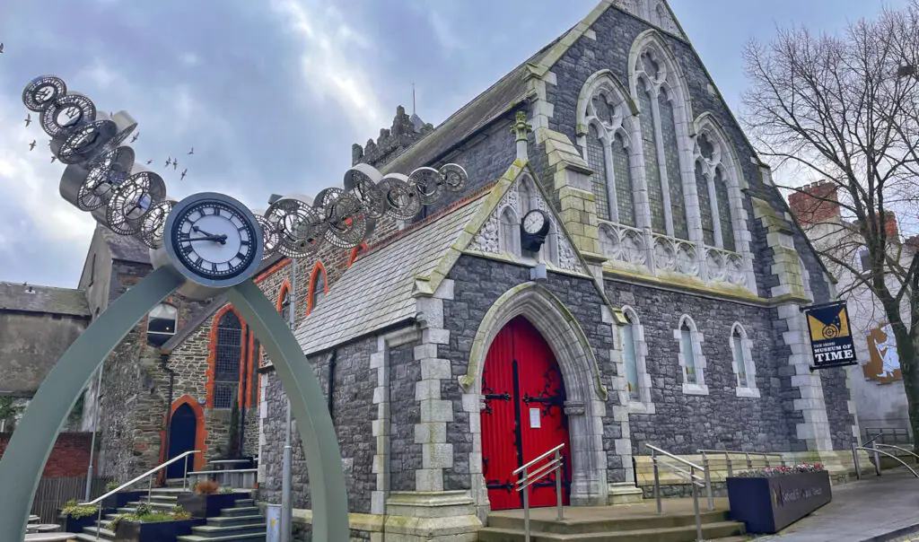 Museum of Time Charming historic building with red doors and unique time sculpture, perfect for a cultural stay near city attractions.